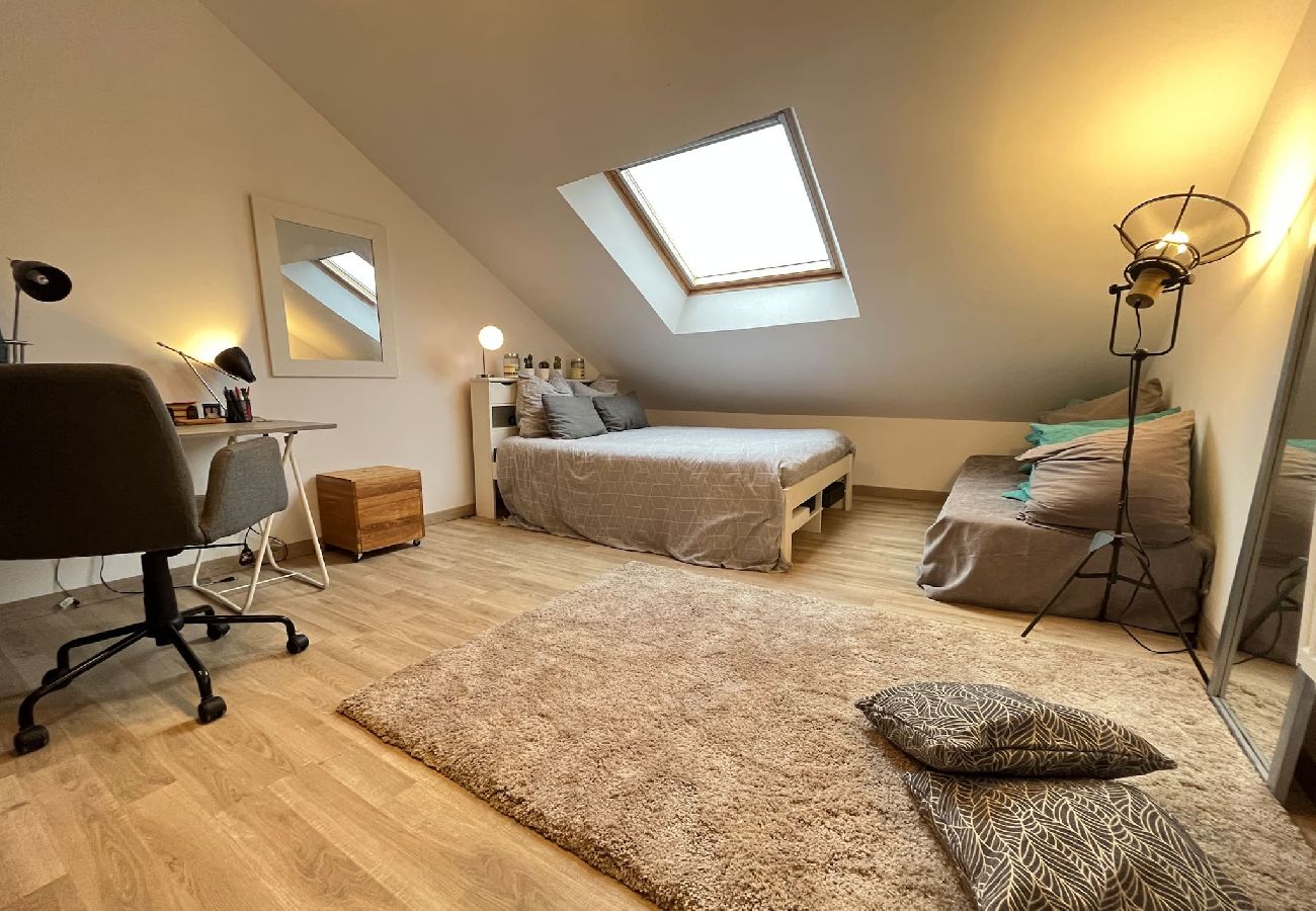 Chambre avec lit double, bureau et coin détente. 