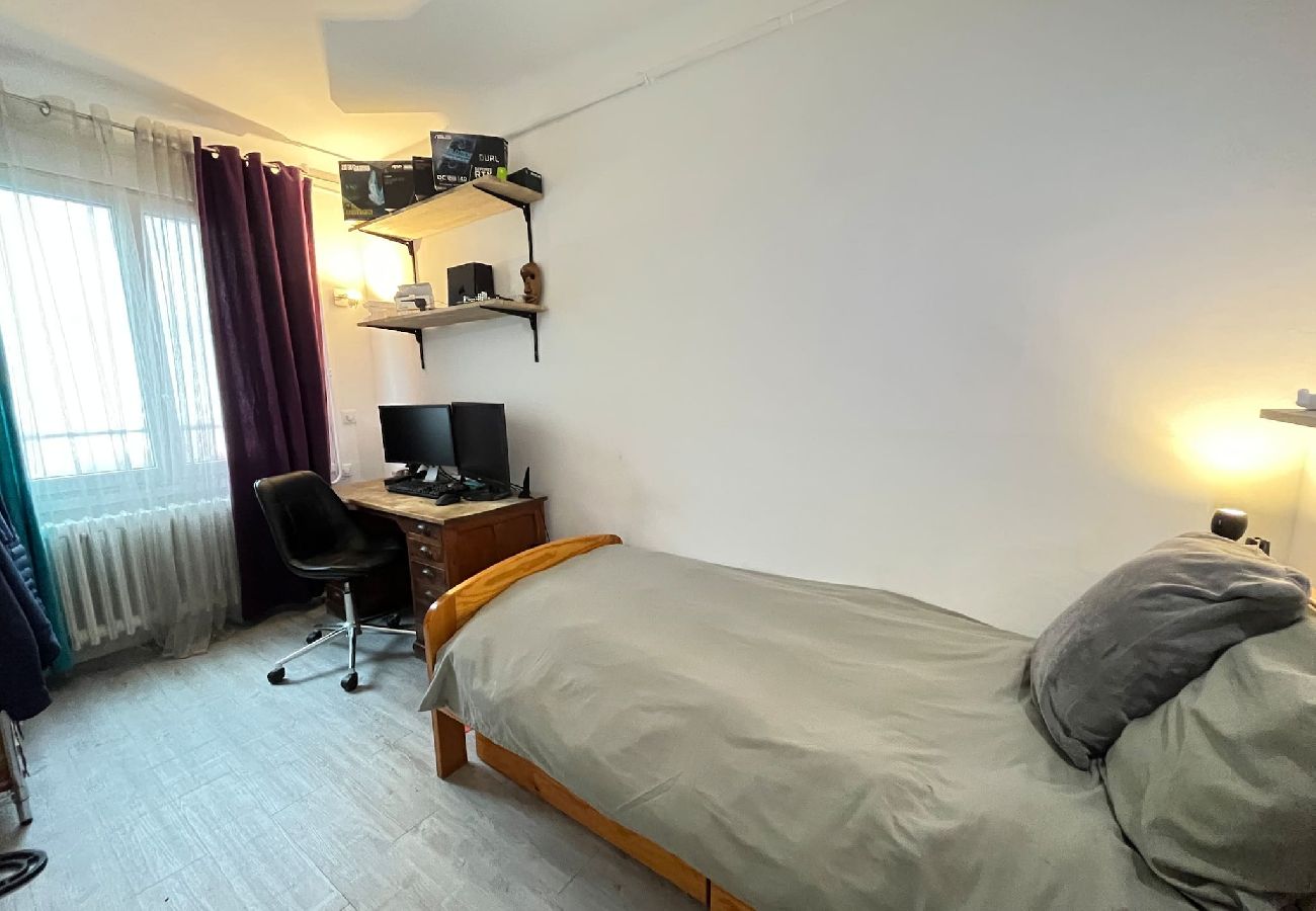 Espace nuit avec lit simple et bureau.
