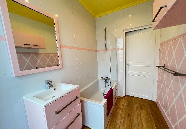 Salle de bain rose, baignoire, meuble vasque